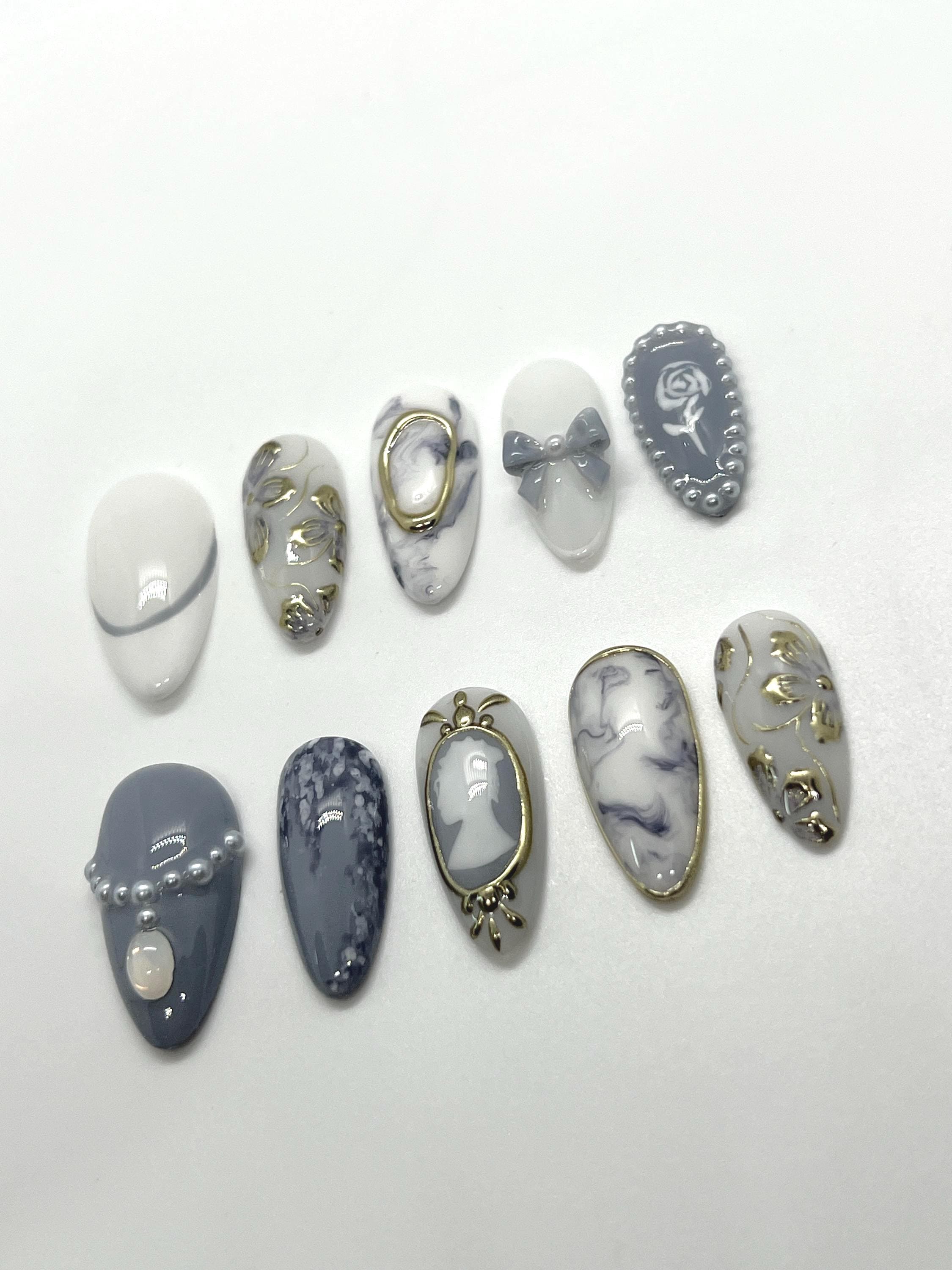 This Bridgerton-inspired handmade press-on nail set captures the elegance and charm of Regency-era balls and whispered society secrets. Featuring soft pastels, pearl-like accents, and delicate gold detailing, these nails offer a refined yet romantic look—perfect for tea parties, formal events, or anyone ready to feel like the season’s most admired diamond.
