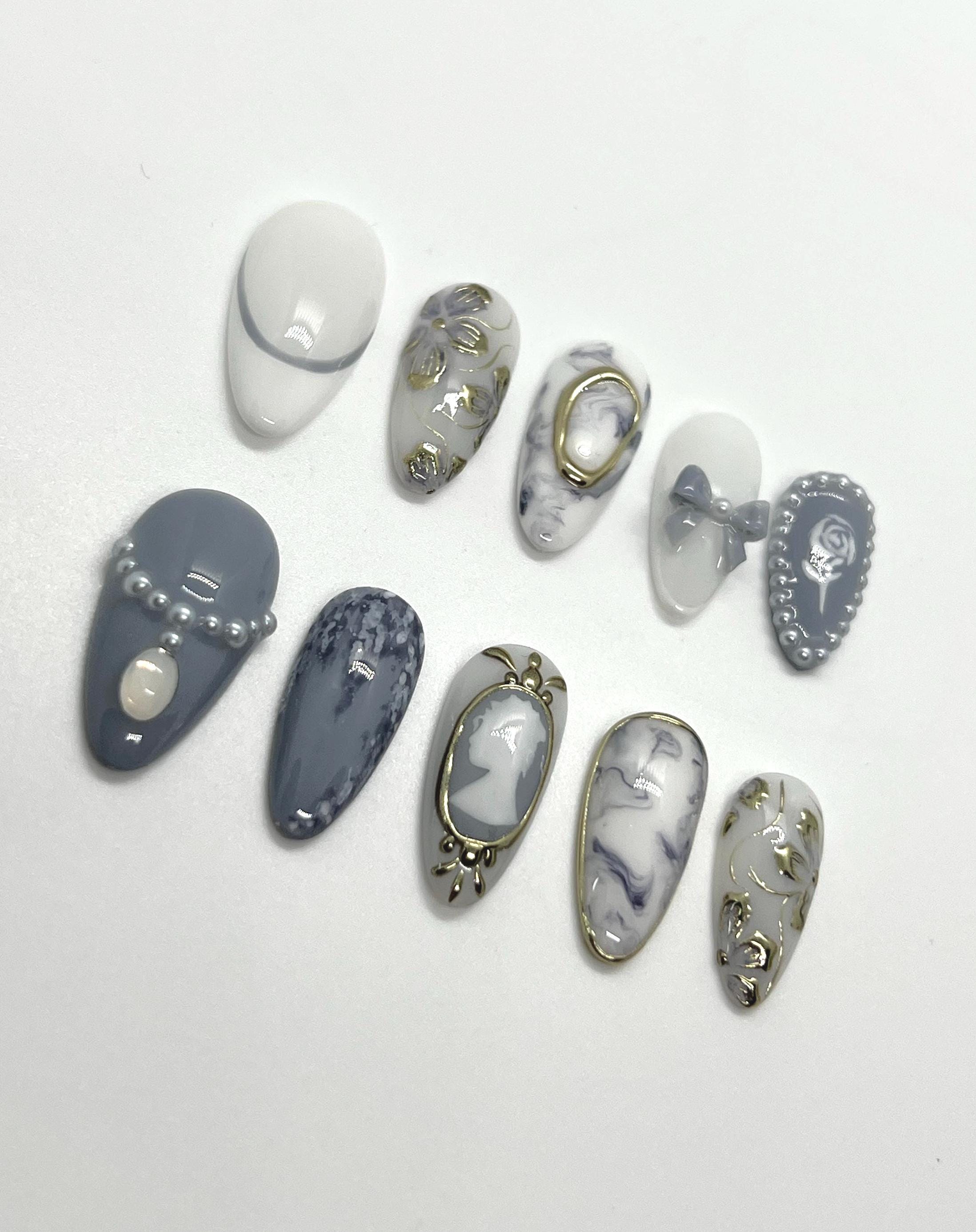 This Bridgerton-inspired handmade press-on nail set captures the elegance and charm of Regency-era balls and whispered society secrets. Featuring soft pastels, pearl-like accents, and delicate gold detailing, these nails offer a refined yet romantic look—perfect for tea parties, formal events, or anyone ready to feel like the season’s most admired diamond.