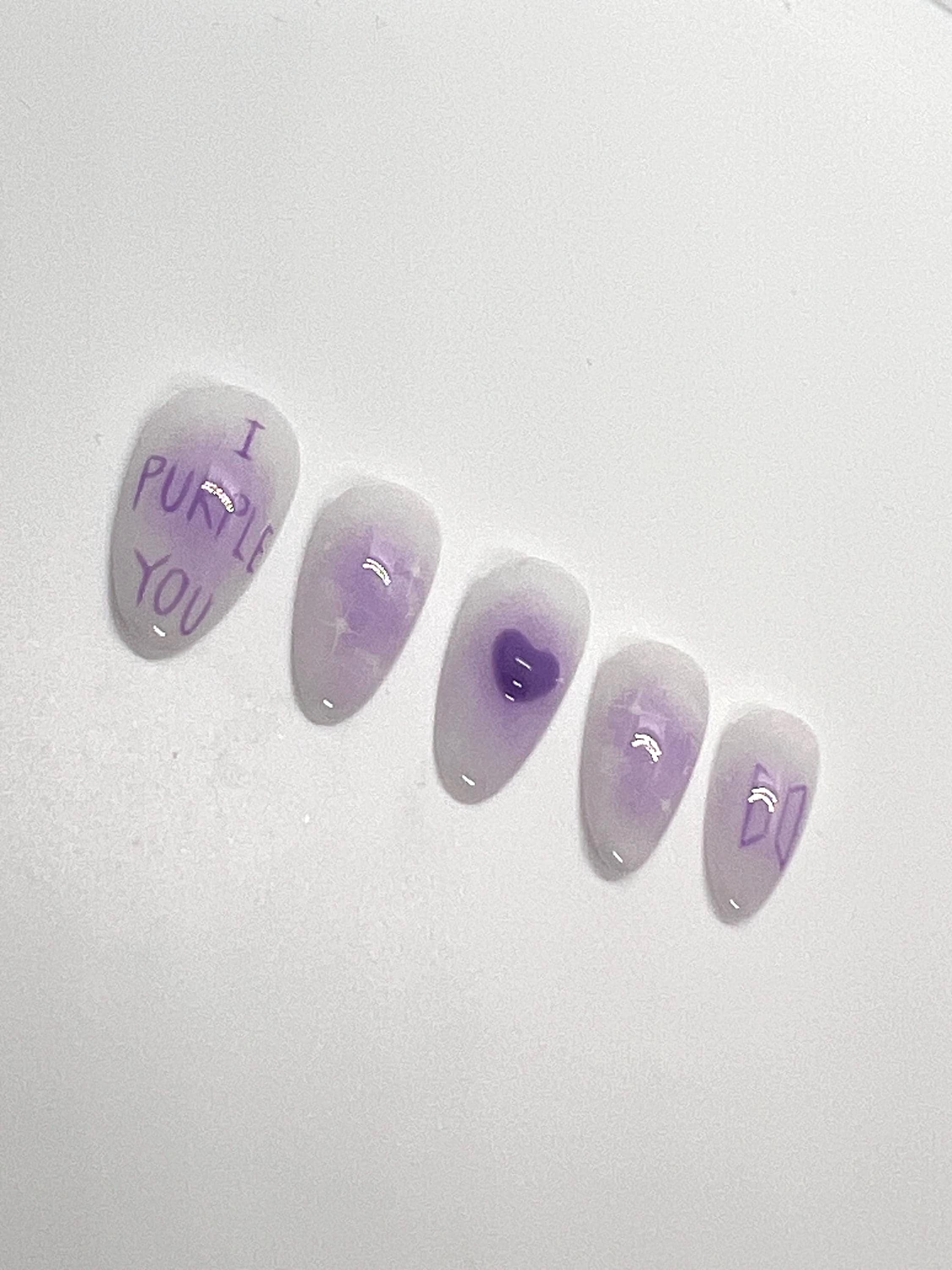 This BTS-inspired handmade press-on nail set features purple and white gradient tones with elegant detailing, inspired by BTS’s signature purple. Designed to represent love, trust, and the lasting bond between artist and fans, these nails are perfect for ARMYs who want a subtle yet meaningful look.